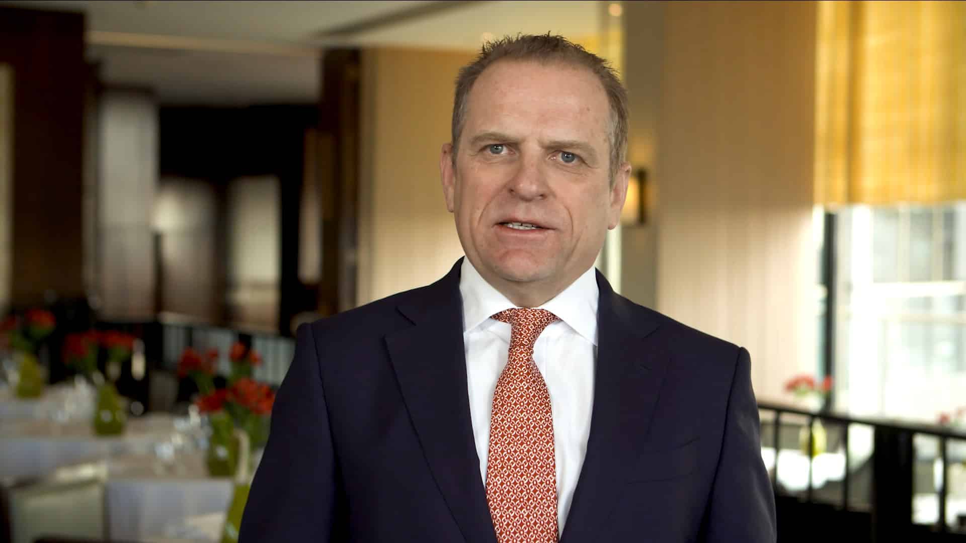 A Hilton manager speaking to camera in a hotel restaurant